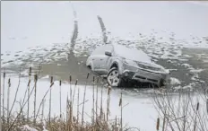  ?? Andrew Rush/Post-Gazette ?? A Subaru Forester broke through the ice Thursday about 15 feet from shore at North Park Lake in McCandless.