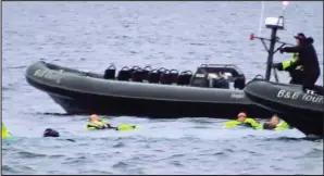  ??  ?? Freezing: Some of the holidaymak­ers wait to be rescued from the sea