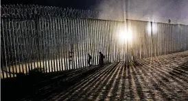  ?? [AP PHOTO] ?? Migrants look Dec. 26 for a hole in the border wall to enter the United States to San Diego, from Tijuana, Mexico. In 2018, religious leaders opposed President Donald Trump’s administra­tion on immigrant family-separation policies and decision to turn away asylum-seekers at the border.