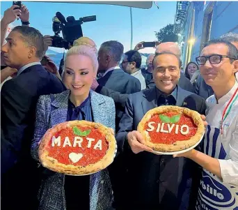  ?? ?? Sul lungomare Silvio Berlusconi e la compagna Marta Fascina con le pizze a loro dedicate da Gino Sorbillo