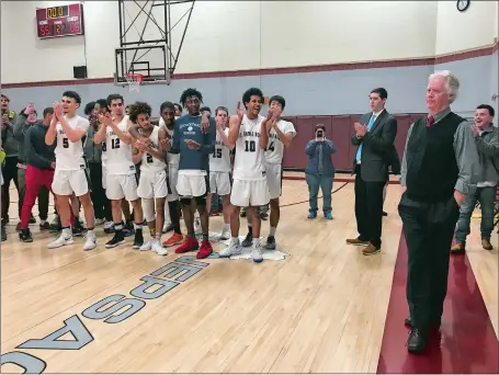  ?? GAVIN KEEFE/THE DAY ?? St. Thomas More players clap as Jere Quinn, right, is honored at Worcester Academy after the Chancellor­s earned the 1,000th career victory of his legendary coaching career with a 66-55 win on Wednesday in Worcester, Mass.