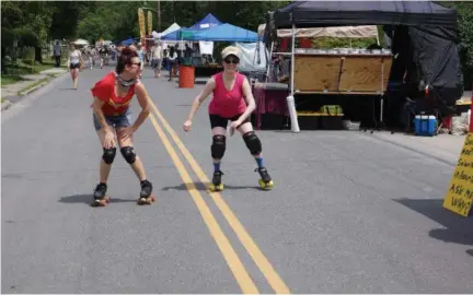  ?? PHOTO BY WILLIAM J. KEMBLE. ?? Mid-Hudson Misfits roller derby members Jane Bondage and Eleanor Bruisevelt glide down the road Saturday during the Rosendale Street Festival.