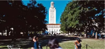  ?? Ashley Landis ?? Estudiante­s y empleados de la Universida­d de Texas caminan por el campus en Austin.