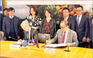  ?? SUPPLIED ?? Finance ministry permanent secretary of state Vongsey Vissoth (seated, right) and AFD’s Cyrille Bellier sign the agreement in the French capital Paris on March 29.