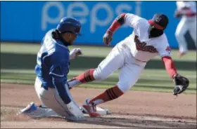  ?? TONY DEJAK — THE ASSOCIATED PRESS ?? The Royals’ Alcides Escobar slides safely into second as Indians’ shortstop Francisco Lindor can’t get to the ball in the fifth inning. Escobar advanced to third on the throwing error by catcher Roberto Perez.