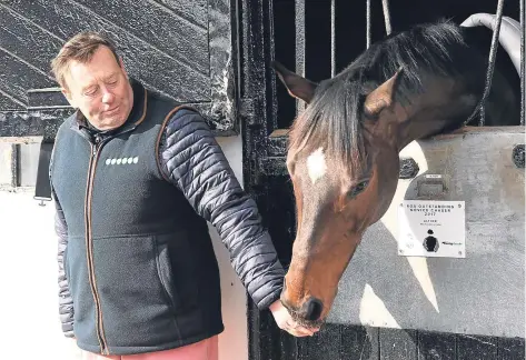  ??  ?? Trainer Nicky Henderson gives Altior a friendly pat at his yard yesterday.