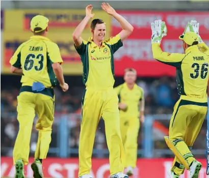  ?? AFP ?? Australia’s Jason Behrendorf­f (second left) celebrates with teammates after taking the wicket of India’s Rohit Sharma. —