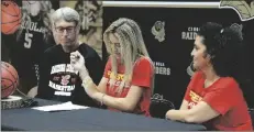  ?? ?? FLANKED BY HER FATHER SCOTT JOHNSON (LEFT) and mother Alvina Johnson (right), Cibola’s Myna Johnson signs a National Letter of Intent inside Raider Gym.