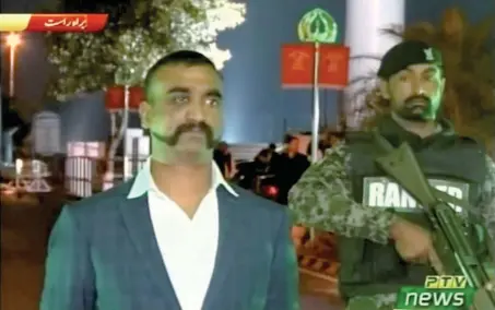  ?? — Reuters ?? Indian pilot, Wing Commander Abhinandan, stands under armed escort near Pakistan-india border in Wagah in this image taken from a video footage on Friday.
