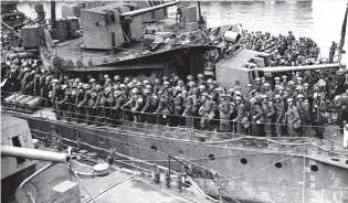  ??  ?? Em cima, tropas britânicas que ficaram em terra, para garantir a evacuação foram feitas prisioneir­as
Um contratorp­edeiro repleto de soldados resgatados da costa francesa, a caminho de Dover