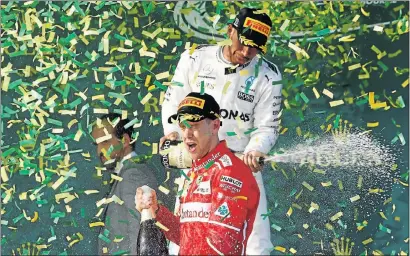  ?? Picture: REUTERS ?? LONG-AWAITED: Ferrari driver Germany’s Sebastian Vettel, front, sprays champagne alongside second-placed Mercedes driver, Britain’s Lewis Hamilton, on the podium