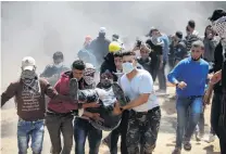  ?? PHOTOS: REUTERS ?? Running for help . . . A wounded Palestinia­n is evacuated during clashes with Israeli troops at the IsraelGaza border at a protest earlier this month demanding the right to return to their homeland.