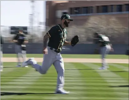  ?? PHOTOS BY DARRON CUMMINGS — THE ASSOCIATED PRESS ?? The A’s Mike Fiers runs a drill during spring training practice on Thursday in Mesa, Ariz.