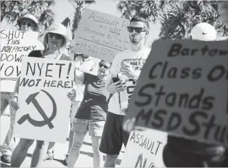  ?? JOE RAEDLE GETTY IMAGES FILE PHOTO ?? Activists protest in front of gun manufactur­er Kalashniko­v USA in Florida after the mass shooting at Marjory Stoneman Douglas High School on Feb. 14. Nobody knows how many students get caught with guns in school.