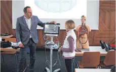 ?? FOTO: KINDERUNI ?? Marie wird von Professor Florian Seeger mit Elektroden ans EKG angeschlos­sen.