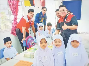  ??  ?? PUAS: Sebahagian sukarelawa­n bersama adik-adik tahun satu.