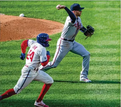  ??  ?? Philadelph­ia’s Roman Quinn runs to first on a bunt as Braves first baseman Freddie Freeman makes the throw to Ozzie Albies for the out during the third inning Saturday in Philadelph­ia. The Braves lost 4-0, as Phllies pitcher Zack Wheeler allowed just one hit over seven innings. Braves starter Charlie Morton gave up three runs in five innings.