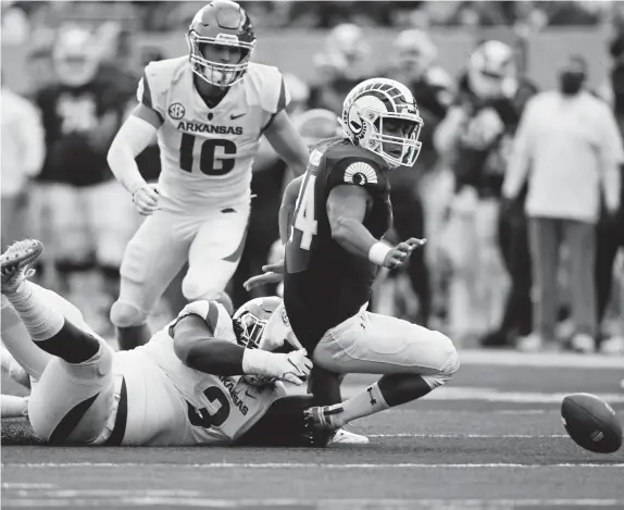  ?? Hyoung Chang, The Denver Post ?? Arkansas’ Mctelvin Agim (3) forces Colorado State’s Izzy Matthews, right, to fumble the ball during a 2018 game at Canvas Stadium.