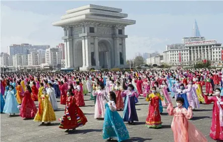  ?? — AP ?? Colours in motion: Women dancing near the Arch of Triumph on the birth anniversar­y of the country’s founder in Pyongyang.