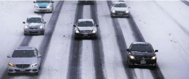  ??  ?? Sub- zero highway Motorists drive along a snow covered northbound Interstate- 94 in Chicago. Night temperatur­es are expected to drasticall­y drop to below minus 20 degrees.
AP