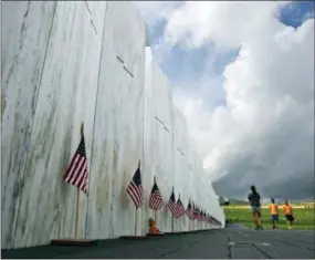  ?? THE ASSOCIATED PRESS ?? Visitors to the Flight 93 National Memorial pause at the Wall of Names honoring 40 passengers and crew members of United Flight 93 killed when the hijacked jet crashed at the site during the 9/11 terrorist attacks, near Shanksvill­e, Pa. Four shipping...