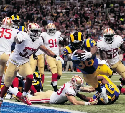  ?? CLIFF HAWKINS/ GETTY IMAGES ?? St. Louis Rams running back Benny Cunningham scores a touchdown in the first quarter against the San Francisco 49ers at Edward Jones Dome on Monday night in St. Louis. Despite trailing 14- 0 after the first quarter, the 49ers won 31- 17.