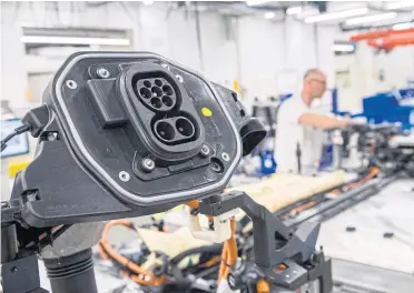  ?? AFP ?? A worker at Volkswagen AG’s Dresden factory assembles the ID 3 electric car. VW is seeking to lower costs in its EV manufactur­ing.