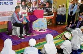  ?? —RICHEL V. UMEL ?? READ-ALONG US Ambassador Sung Kim tells a story to pupils of Amai Pakpak Elementary School at Barrio Green, Marawi City, during a read-along session on Tuesday.