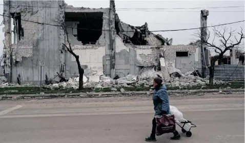  ?? | Reuters ?? A RESIDENT walks past a building destroyed during the Ukraine-Russia conflict in the southern port city of Mariupol, Ukraine.