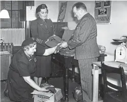  ??  ?? Members of the Royal Voluntary Service packing up knitted gloves and scarves for servicemen in the Korean War. The photograph was taken in 1951. See more about the service above.