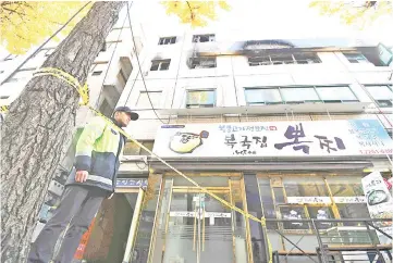  ??  ?? A South Korean policeman stands guard outside the scene after a fire. — AFP photo