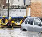  ??  ?? RESCUERS Team rows through town