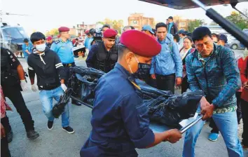  ?? AP ?? Officials unload the bodies after a helicopter carrying the remains of those killed on Nepal’s Gurja Himal mountain arrived at the Teaching Hospital in Kathmandu yesterday.