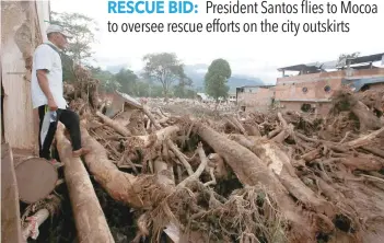  ?? — Reuters ?? A man looks at a destroyed area after heavy rains caused several rivers to overflow, pushing sediment and rocks into buildings and roads in Mocoa.