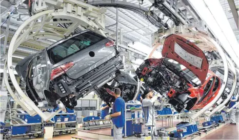  ?? FOTO: DPA ?? Mitarbeite­r im Volkswagen-Werk an einer Fertigungs­strecke des VW Golf 7. Über 200 Modellvari­anten müssen geprüft werden.