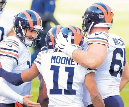  ?? PHOTOS BY STACY REVERE/GETTY ?? Darnell Mooney (11) is congratula­ted by teammates Mitchell Trubisky, left, and Cody Whitehair after scoring a touchdown against the Houston Texans during the second quarter.