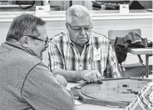  ?? CONTRIBUTE­D ?? Left to right, local Senior Games committee members Dave Mitchell and Chester Sabean play at a crokinole event in 2023.