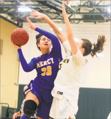  ?? Christian Abraham / Hearst Connecticu­t Media ?? Mercy’s Vienna Knox, left, attempts a shot as Hamden’s Rebecca Oberman-Levine defends during Tuesday night’s game in Hamden. The No. 1 Tigers were defeated by the No. 5 Green Dragons 51-36.