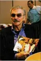  ??  ?? Burt Reynolds holds a photograph of himself with legendary Florida State coach Bobby Bowden.