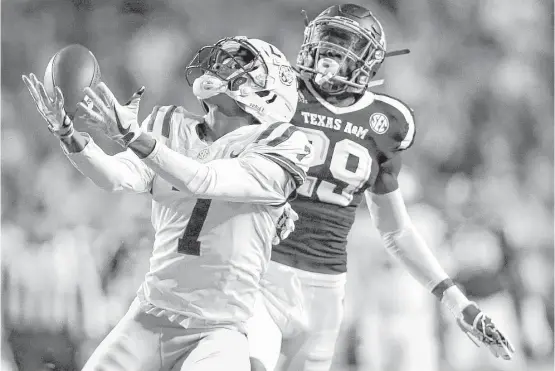  ?? Sean Gardner / Getty Images ?? LSU’s D.J. Chark catches a pass as Texas A&M’s Debione Renfro defends during the first half at Tiger Stadium in Baton Rouge, La., on Saturday night.