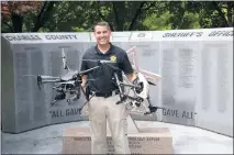  ?? CCSO PHOTO ?? Charles County Sheriff’s Office Capt. David Kelly posed for a photograph with a couple of the drones his team uses in a host of different situations.