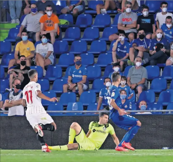  ??  ?? Erik Lamela consigue el gol del Sevilla tras un disparo de Rafa Mir al poste ante la impotencia de Soria y los defensores del Getafe.