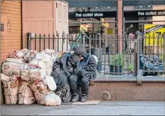  ?? Alexi Rosenfeld / Getty Images ?? Two people sleep on each other next to their belongings in New York City in May 2020.