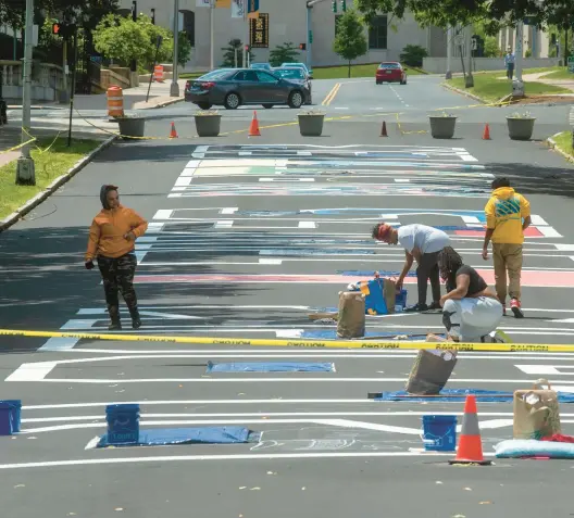  ?? AARON FLAUM/HARTFORD COURANT ?? Local artists repaint the Black Lives Matter mural on Trinity Street on June 6, 2023, after it was vandalized.