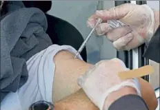  ?? Matt stone / boston Herald ?? Fire capt. craig robinson of the marshfield Fire department gives a covid-19 vaccine to a patient at a drive-up vaccinatio­n site at the marshfield Fairground­s on tuesday.