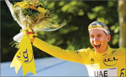  ??  ?? Tour de France winner Slovenia’s Tadej Pogacar, wearing the overall leader’s yellow jersey, celebrates on the podium after the twenty-first and last stage of the Tour de France cycling race over 108.4 kilometers (67.4 miles) with start in Chatou and finish on the Champs Elysees in Paris, France. (AP)