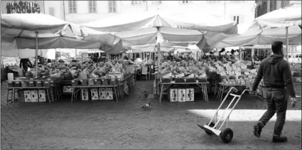  ?? AP PHOTO/ANDREW MEDICHINI ?? A man pulls a trolley at an emtpy Campo dei Fiori open-air market, in Rome, on Tuesday. The Italian government is assuring its citizens that supermarke­ts will remain open and stocked after panic buying erupted after broad anti-virus measures were announced nationwide, sparking overnight runs on 24-hour markets.