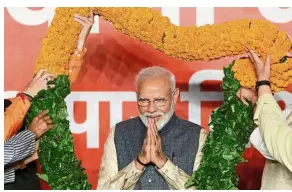  ??  ?? Landslide victory: Modi being presented with a garland by BJP leaders after the election results in New Delhi, India. — Reuters