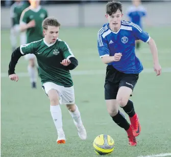  ??  ?? Reynolds’ Chase Haagensen, right, tries to get away from Oak Bay’s Liam Carter Sullivan during the Colonist Cup final Monday at Oak Bay Secondary.