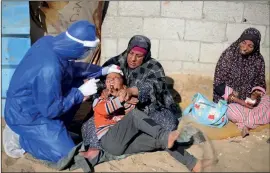  ??  ?? A Palestinia­n child being vaccinated by Israel near the Ramallah crossing, above. Right: a tweet discouragi­ng cooperatio­n in the fight against Covid